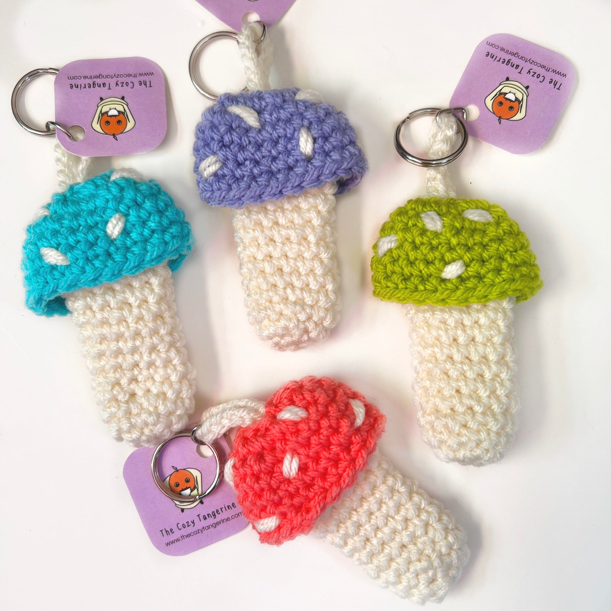 blue, purple, green and peachy pink mushroom lighter holder keychain. mushie chapstick carrying case